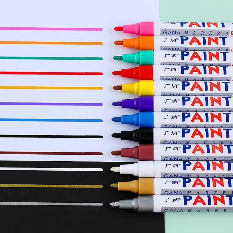 A collection of various colored paint marker pens arranged in a row against a light green background.