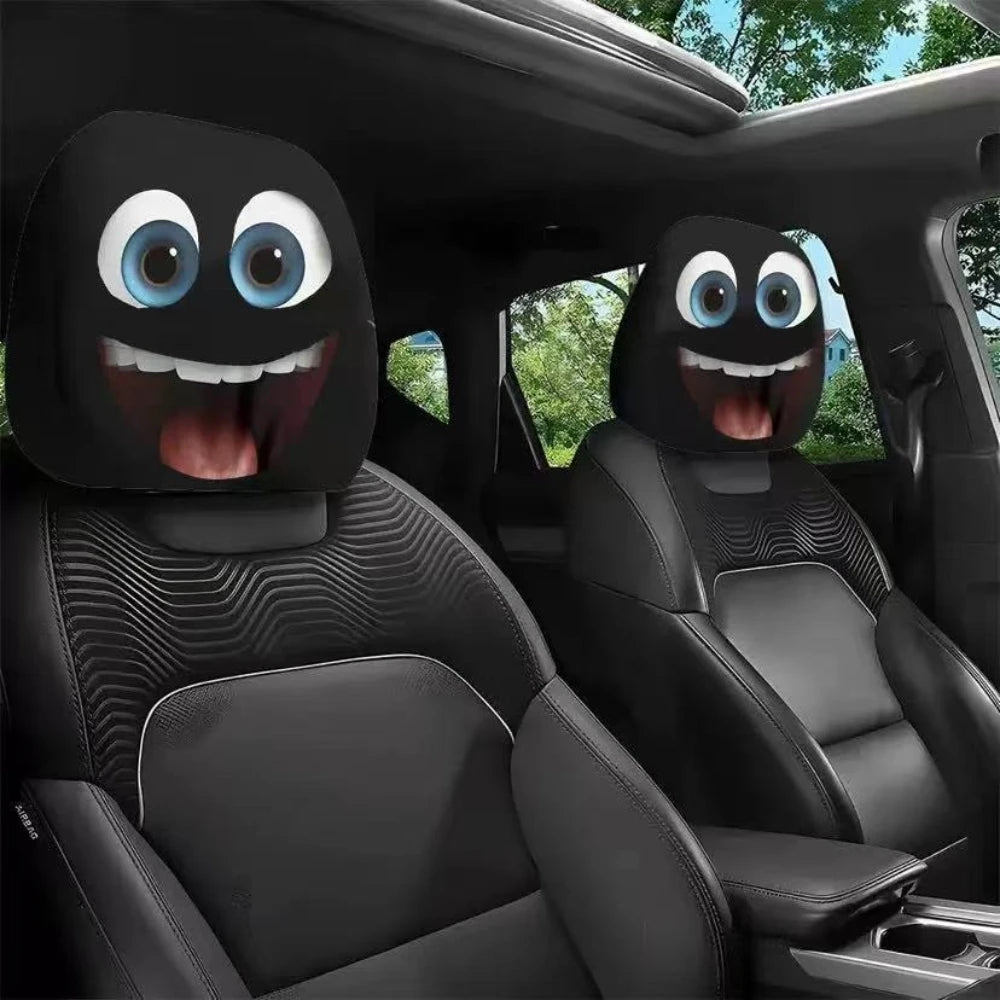 Two black horror themed car headrest covers with glowing blue eyes installed in a vehicle seat.