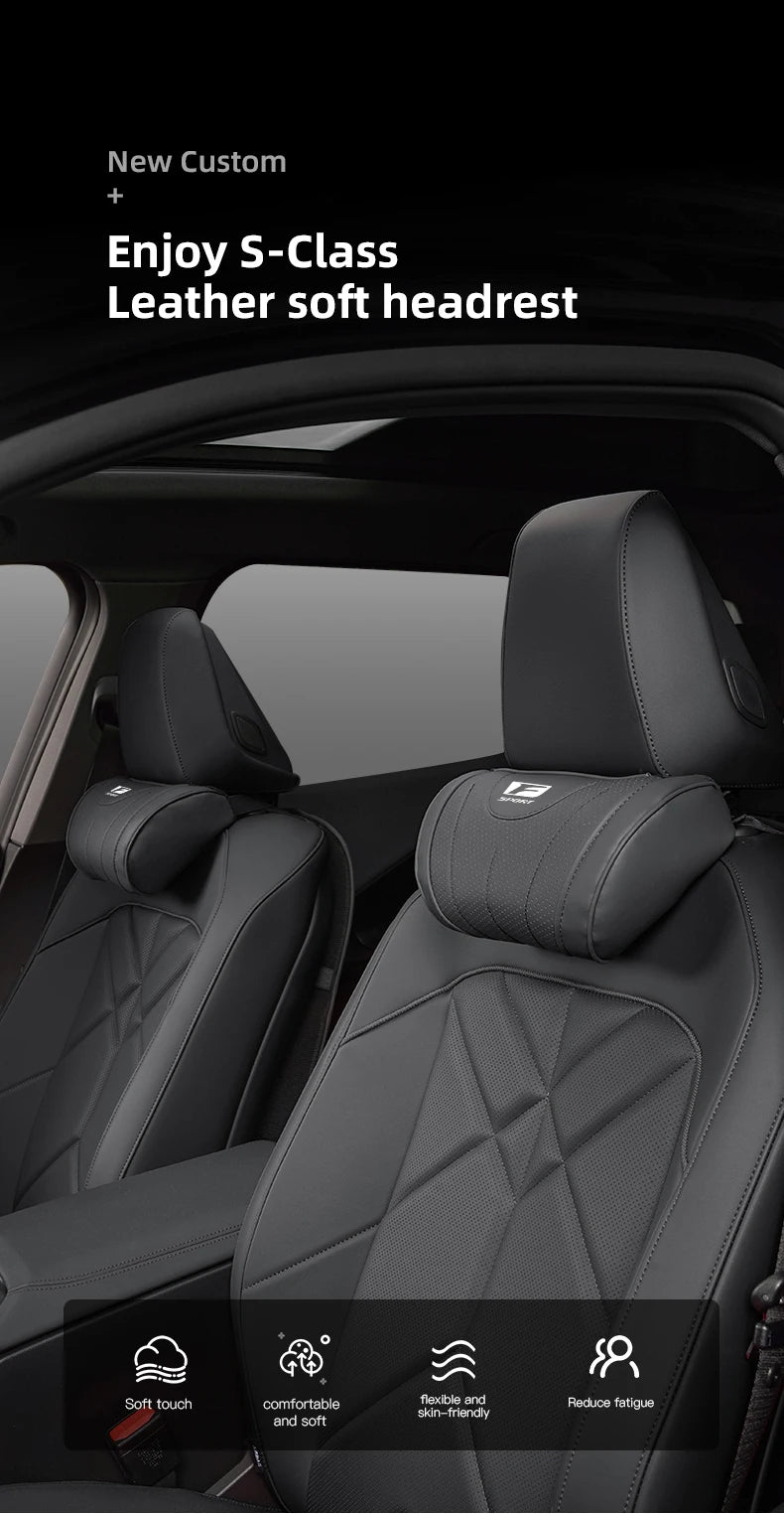 Close-up view of a black leather car seat with an S-Class leather soft headrest and neck pillow.