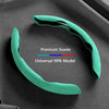 A teal suede steering wheel cover is shown against a dark gray background, highlighting its universal fit.
