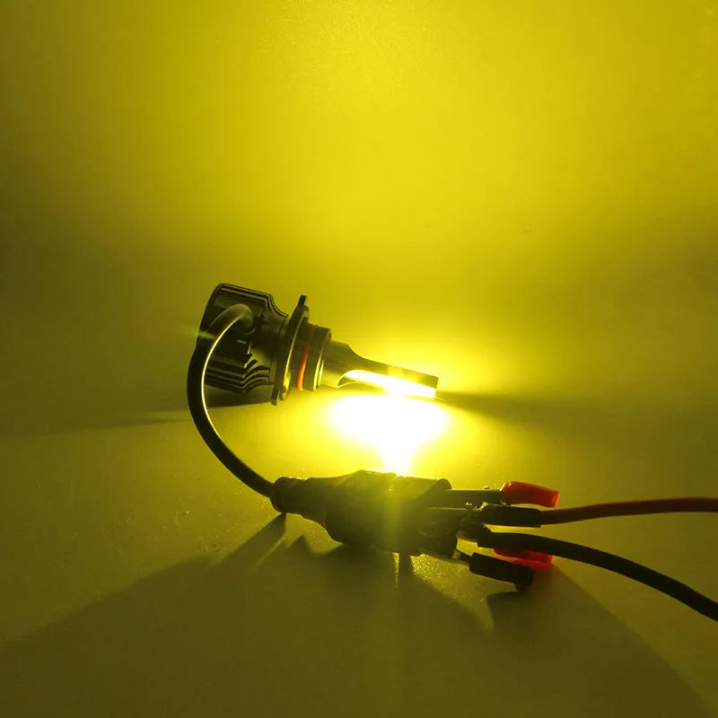A bright yellow-green fog light bulb is illuminated against a dark background.