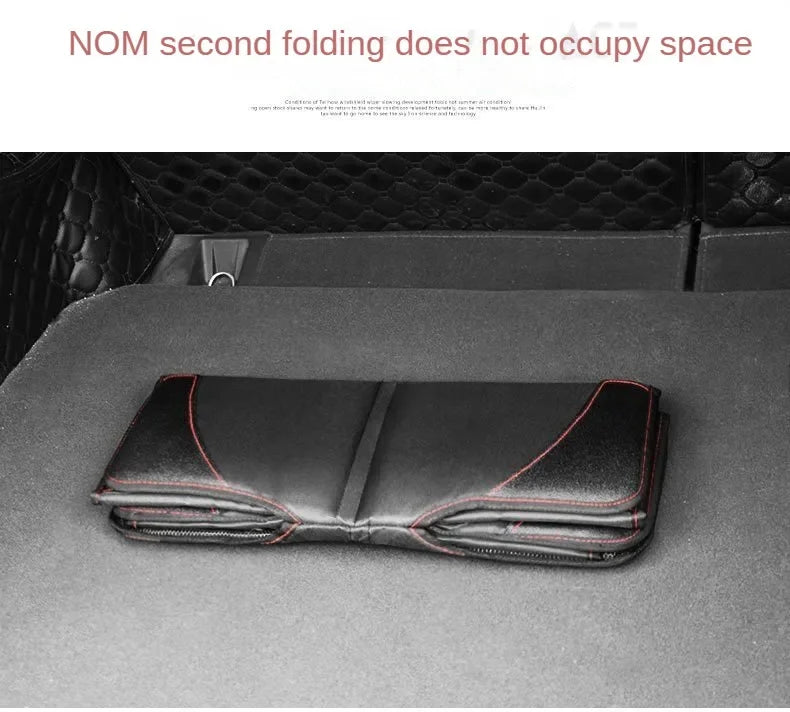 A black car seat protector cover is shown folded on a dark surface.