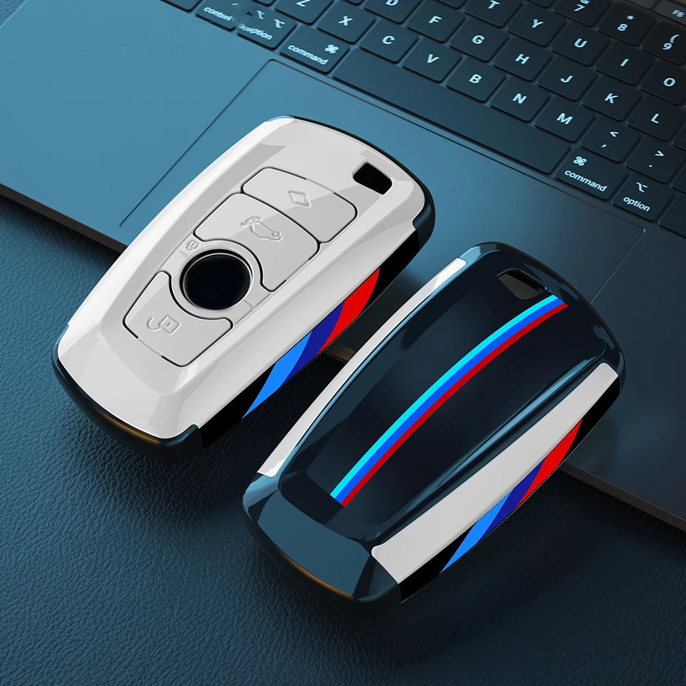 Un juego de fundas para llaves de coche de fibra de carbono sobre un teclado de portátil oscuro.