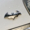 Silberner Metall-Bat-Aufkleber-Abzeichen vor hellem Hintergrund, möglicherweise für Auto oder Motorrad.