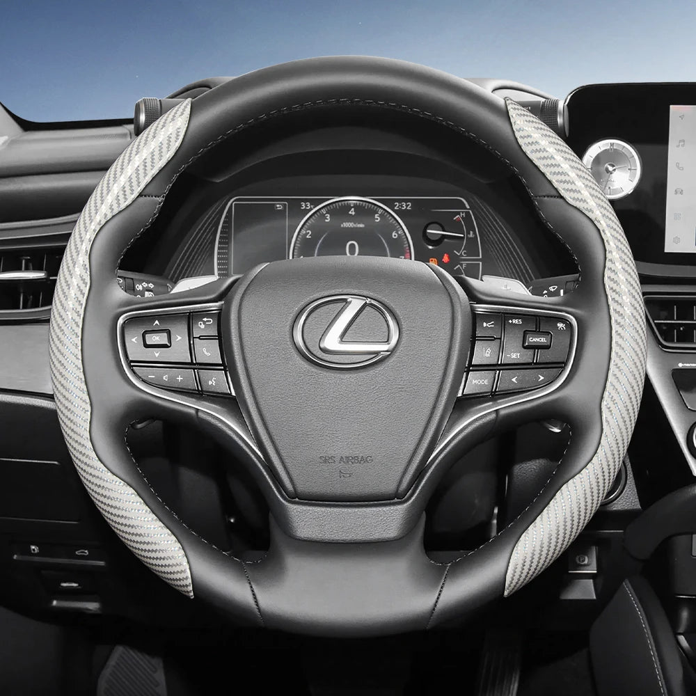 Close-up view of a black Lexus steering wheel with carbon fiber patterned covers and controls.