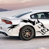 A white sports car features black wolf decals on the side while parked outdoors.