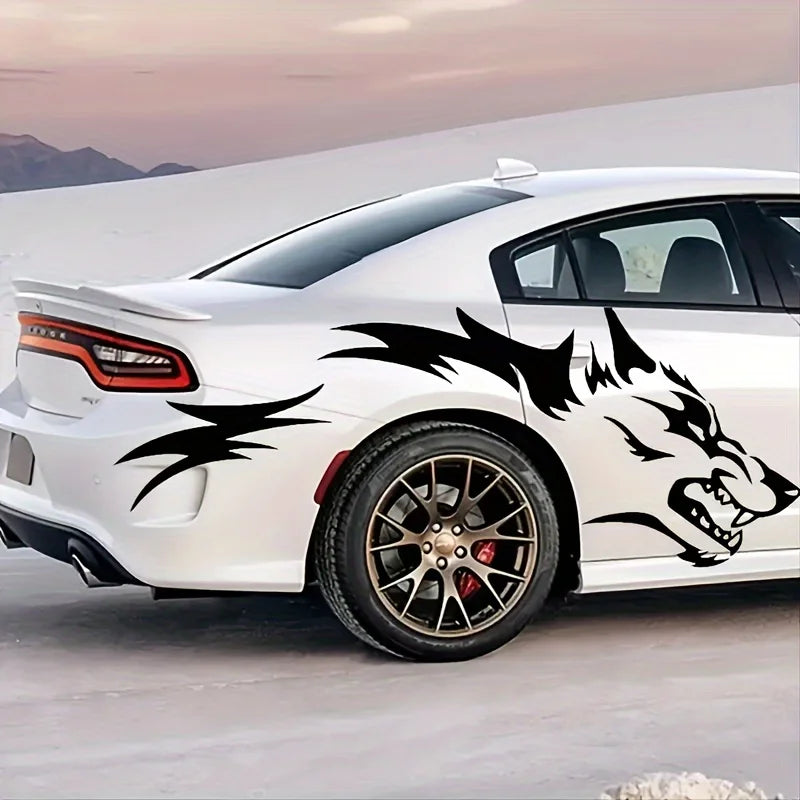 A white sports car features black wolf decals on the side while parked outdoors.