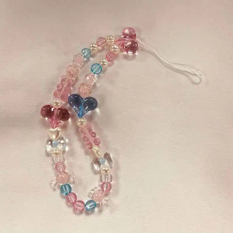 A necklace featuring round beads in shades of pink, blue, and clear, strung on a white cord.
