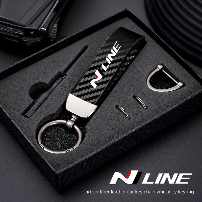 A black box containing a carbon fiber leather car key chain with a zinc alloy keyring.