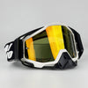A pair of black and white off-road motorcycle riding goggles with yellow tinted lenses.
