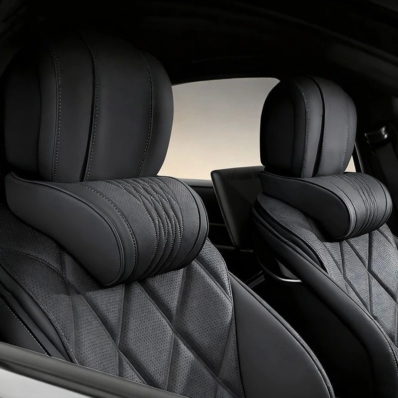 Black memory foam car headrests with leather covers shown inside a vehicle cabin.