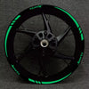 A black motorcycle wheel with bright green sports decals and spokes.