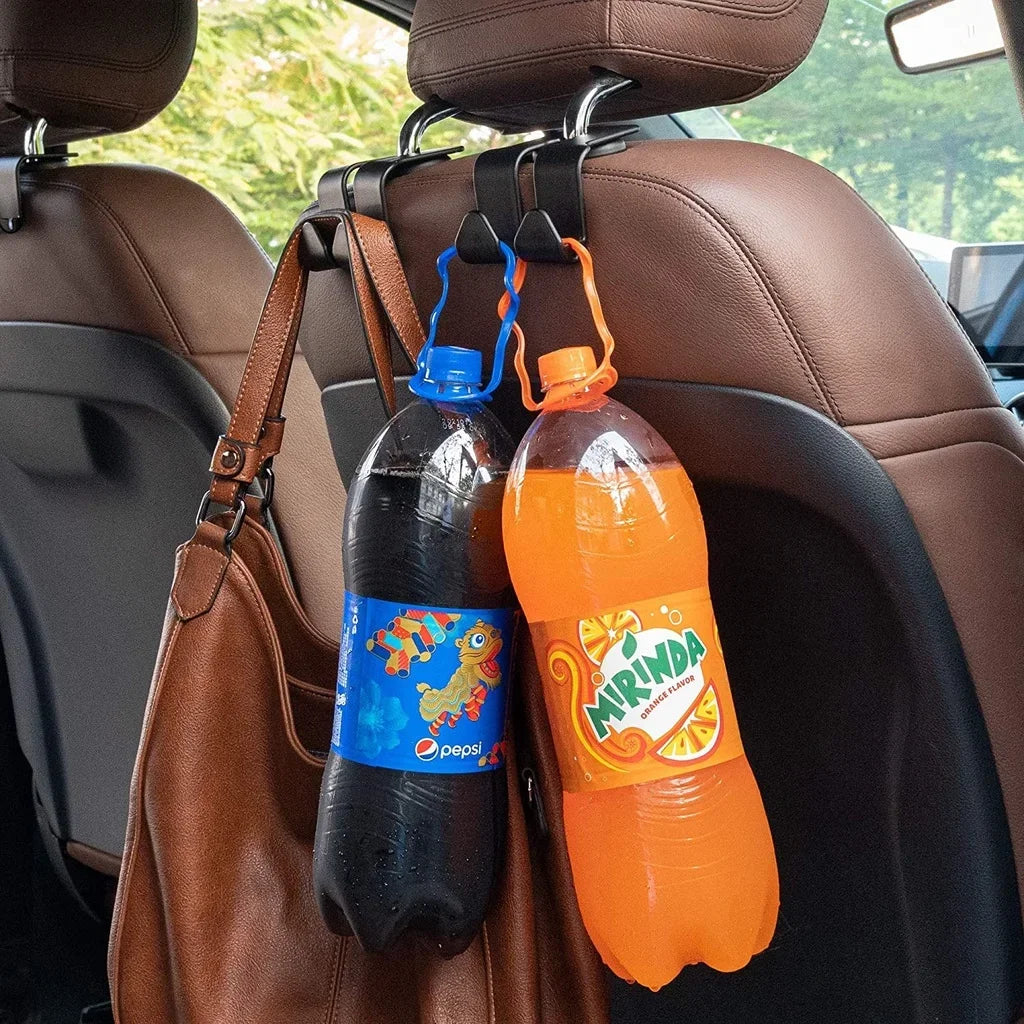 A bottle of Pepsi and a bottle of Miranda juice hanging from car seat headrest hooks.
