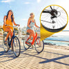 Two women riding bicycles on a boardwalk with a close-up of a bicycle tire valve cap set.