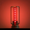 Glasröhrchen mit rotem LED-Streifen, leuchtend rot, vor rotem Hintergrund.
