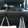 Black universal car seat back headrest storage hooks with clear plastic bags hanging from them