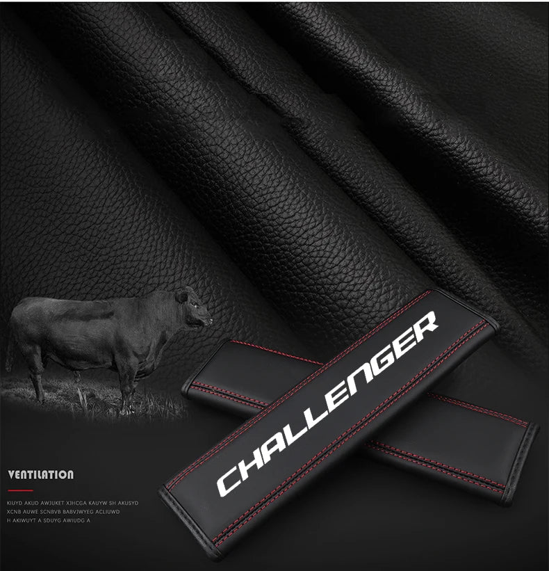 Black leather car seat belt shoulder strap pad with red stitching shown against a dark background.