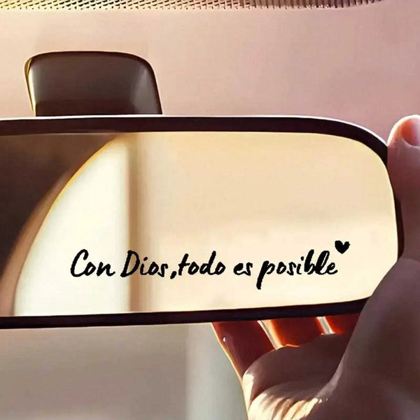 A close-up of a car mirror featuring the Spanish phrase Con Dios todo es posible written in black script.