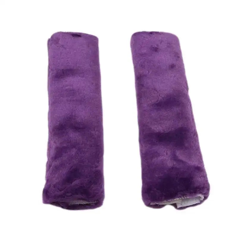A pair of purple luxury car seatbelt shoulder pads.