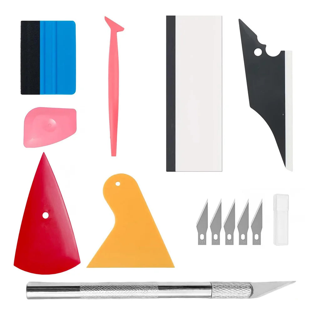 A kit of professional automotive film installation tools including various blades, a pink tool, and a silver knife.