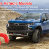 A blue Chevrolet Silverado pickup truck is driving on a dirt road, with red silicone tow hitch covers visible in the foregrou