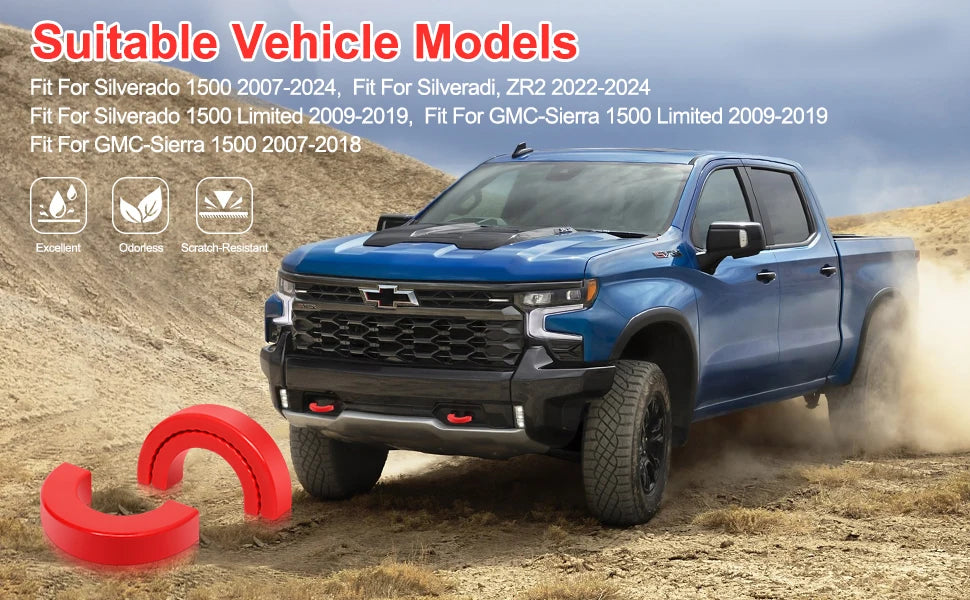 A blue Chevrolet Silverado pickup truck is driving on a dirt road, with red silicone tow hitch covers visible in the foregrou