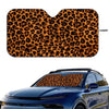 A leopard print car sunshade applied to the windshield of a blue car.