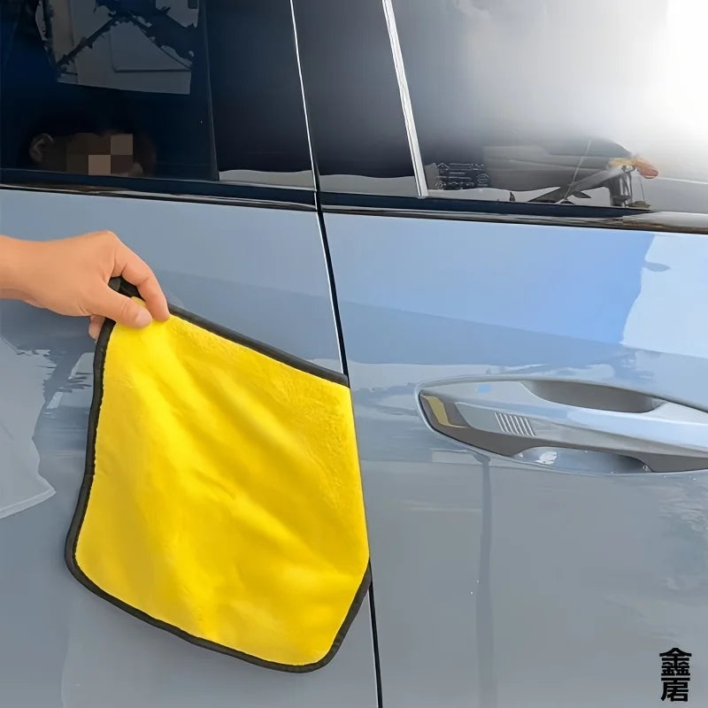 A hand is holding a yellow car door edge weatherstrip seal strip against a silver car door.