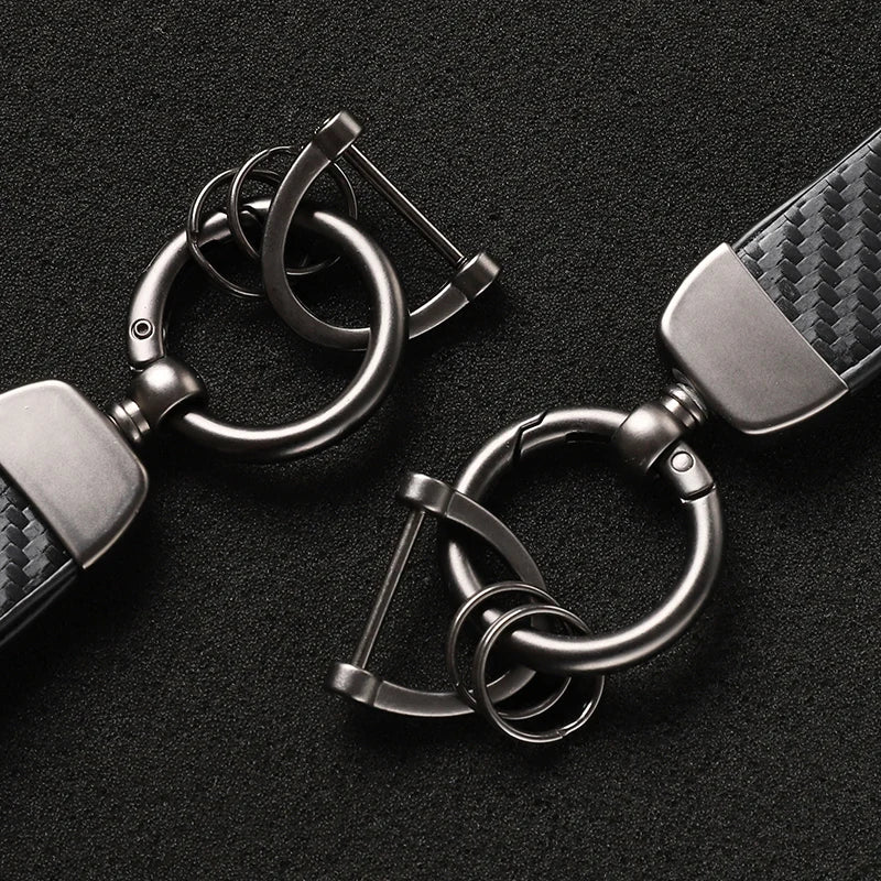 Silver luxury carbon fiber style keychains with metal split rings displayed on a black background