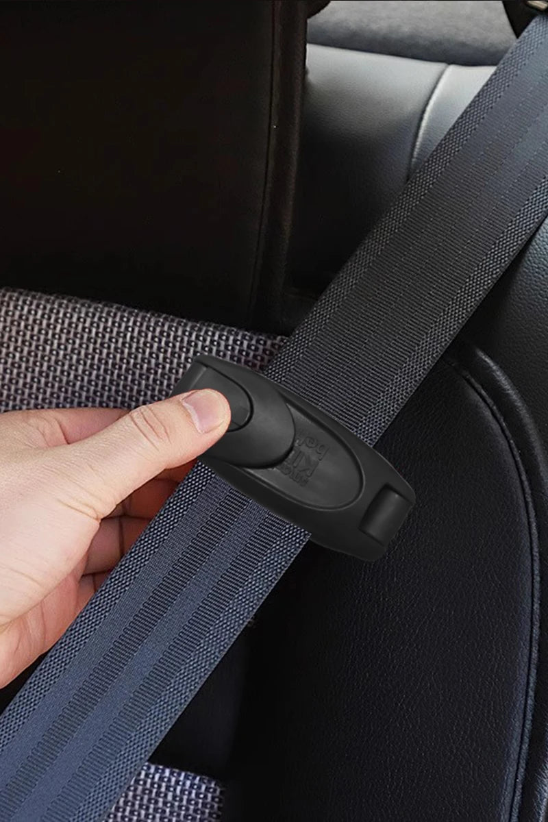 A hand is clipping a black seat belt strap onto a dark car seat or upholstery.
