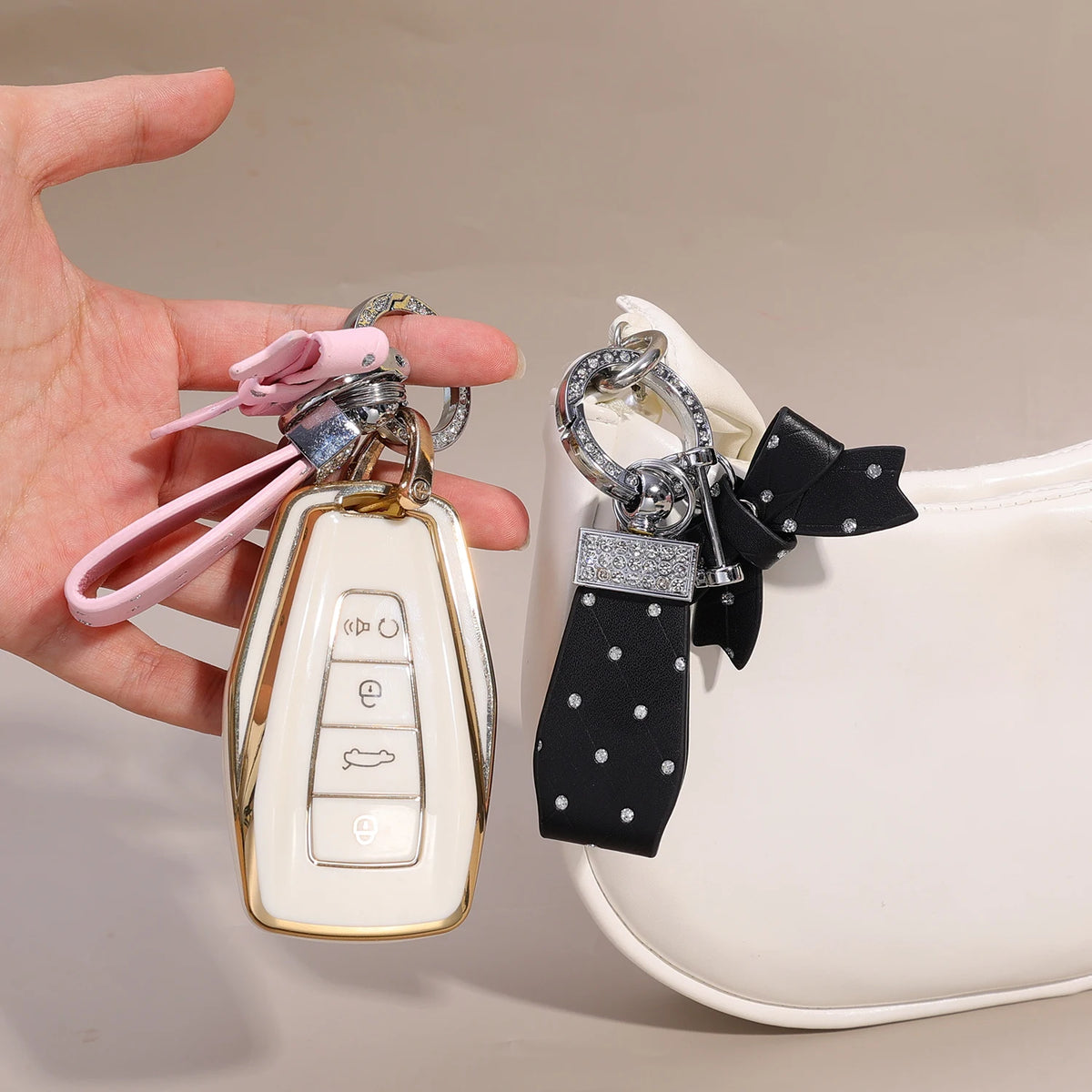 Eine Hand hält eine weiße Luxus-PU-Ledertasche mit einem schwarzen Schleifen-Anhänger.
