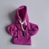 A bright pink hoodie cover with a drawstring detail is displayed on a white surface.