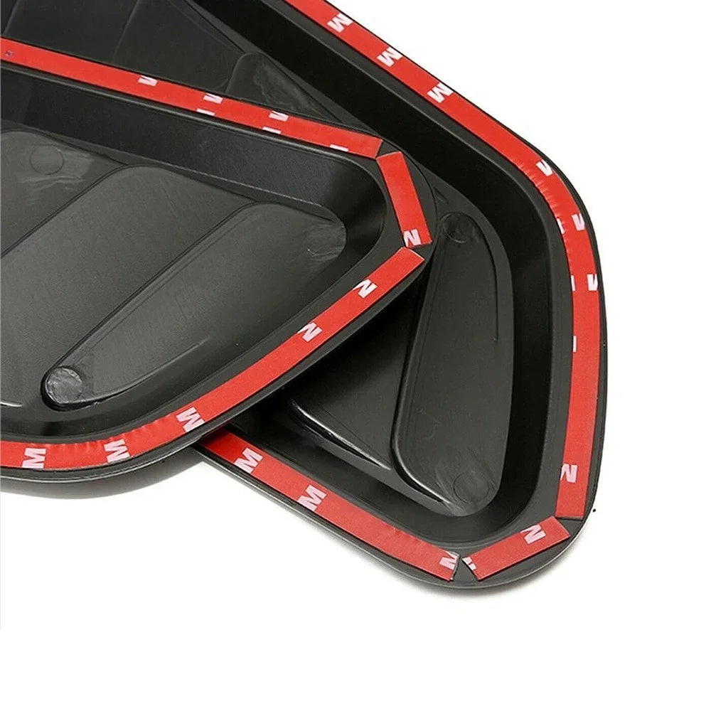 Close-up view of a black carbon fiber car hood scoop vent trim with red accents.
