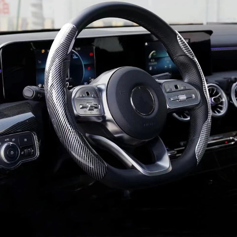 Close-up view of a black steering wheel with an ultra-thin carbon fiber cover and modern controls.
