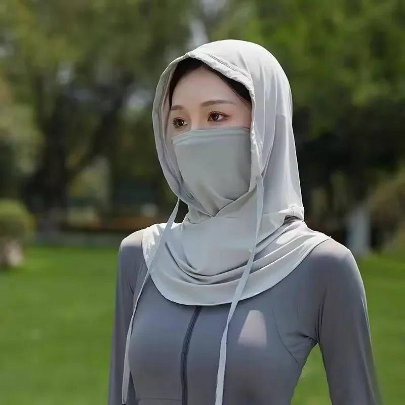 Une femme portant un masque facial multifonctionnel et respirant gris clair pour les activités de plein air.