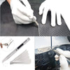 A hand uses a professional window tinting and vinyl wrapping tool kit to apply a film to a glass surface.