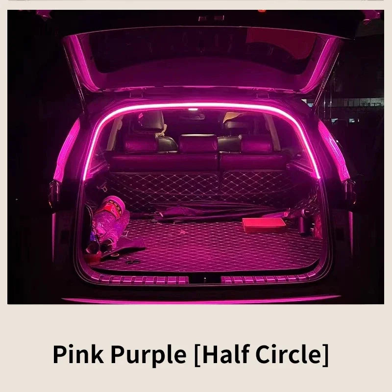 Bande lumineuse LED rose-violette en demi-cercle éclairant l'intérieur du coffre d'une voiture.