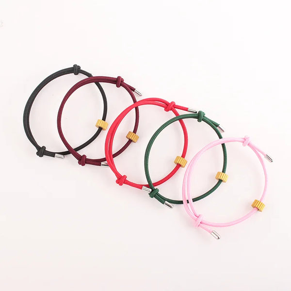 A collection of heart-shaped fitness tracker bracelets in black, red, green, and pink.