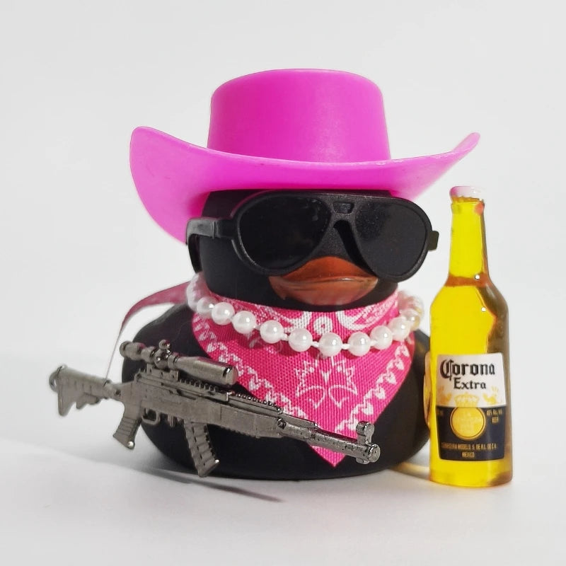 A black rubber duck shaped ornament wearing a pink cowboy hat and pink bandana, next to a bottle of Corona Extra.