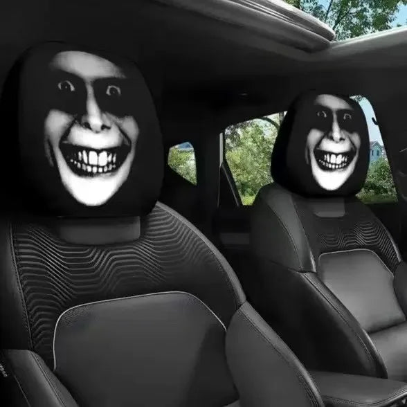 Two car headrest covers featuring stylized, grinning horror faces are visible in a vehicle interior.