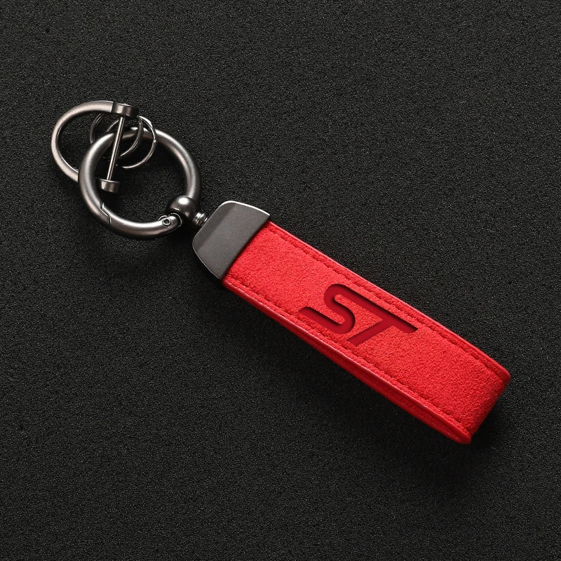 A red suede leather car keychain with a silver split ring and metal hardware.