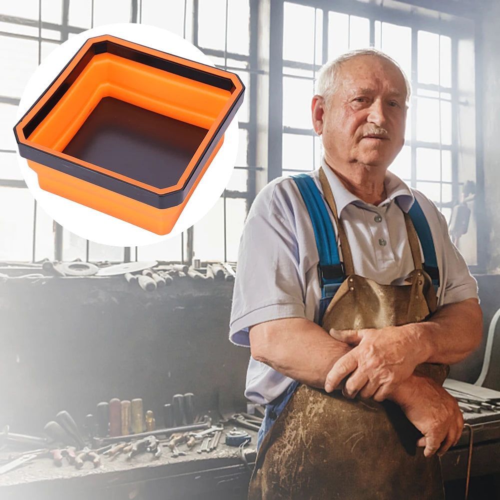 A man wearing an apron holds up an orange collapsible magnetic parts tray organizer.