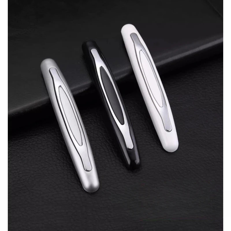 Three silver and black car door edge protection strips displayed on a dark surface.