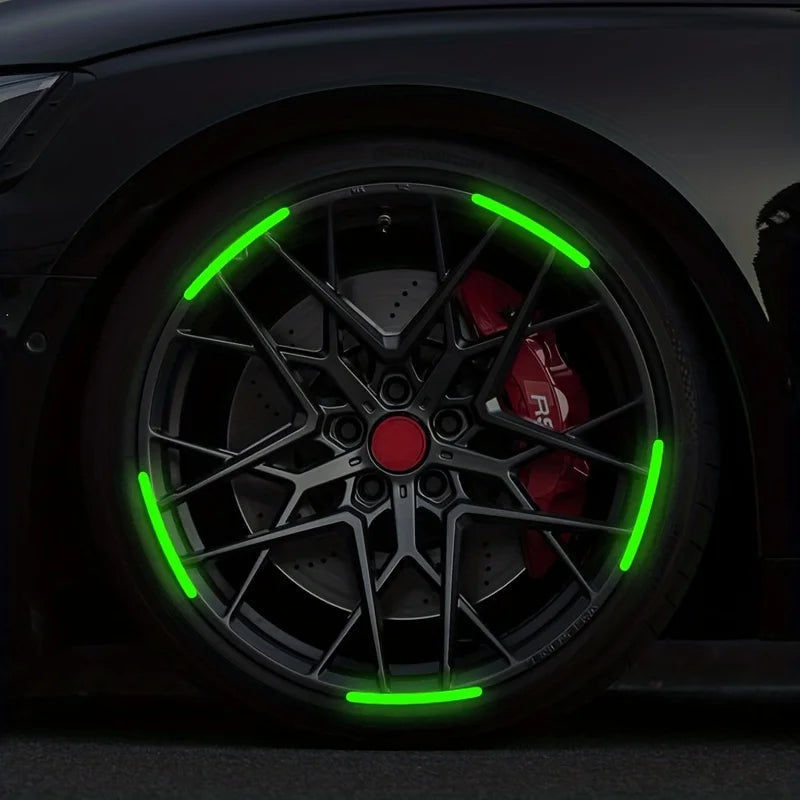 Close-up of a black car wheel with bright green reflective decals and spokes.