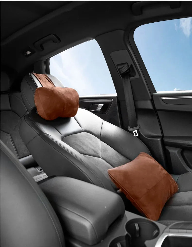 Un coussin de soutien au cou marron est placé sur l'appui-tête en cuir d'un siège de voiture.