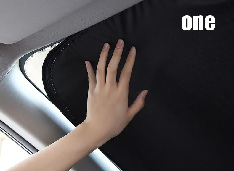 Une main touche un pare-soleil de voiture noire à l'intérieur d'un véhicule.