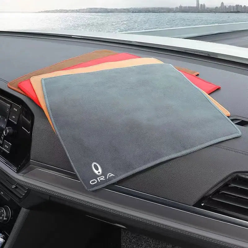 A set of multi-sided coral fleece drying towels in various colors resting on a dark car surface.