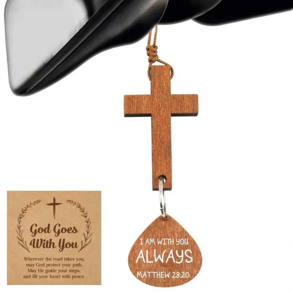 A wooden cross ornament with the inscription I am with you always and Matthew 28:20 hanging from a black strap.