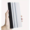 A hand holds a precision scratch-free decal applicator tool with black and silver strips.