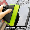 A hand is using a bright lime green squeegee to clean a window surface.